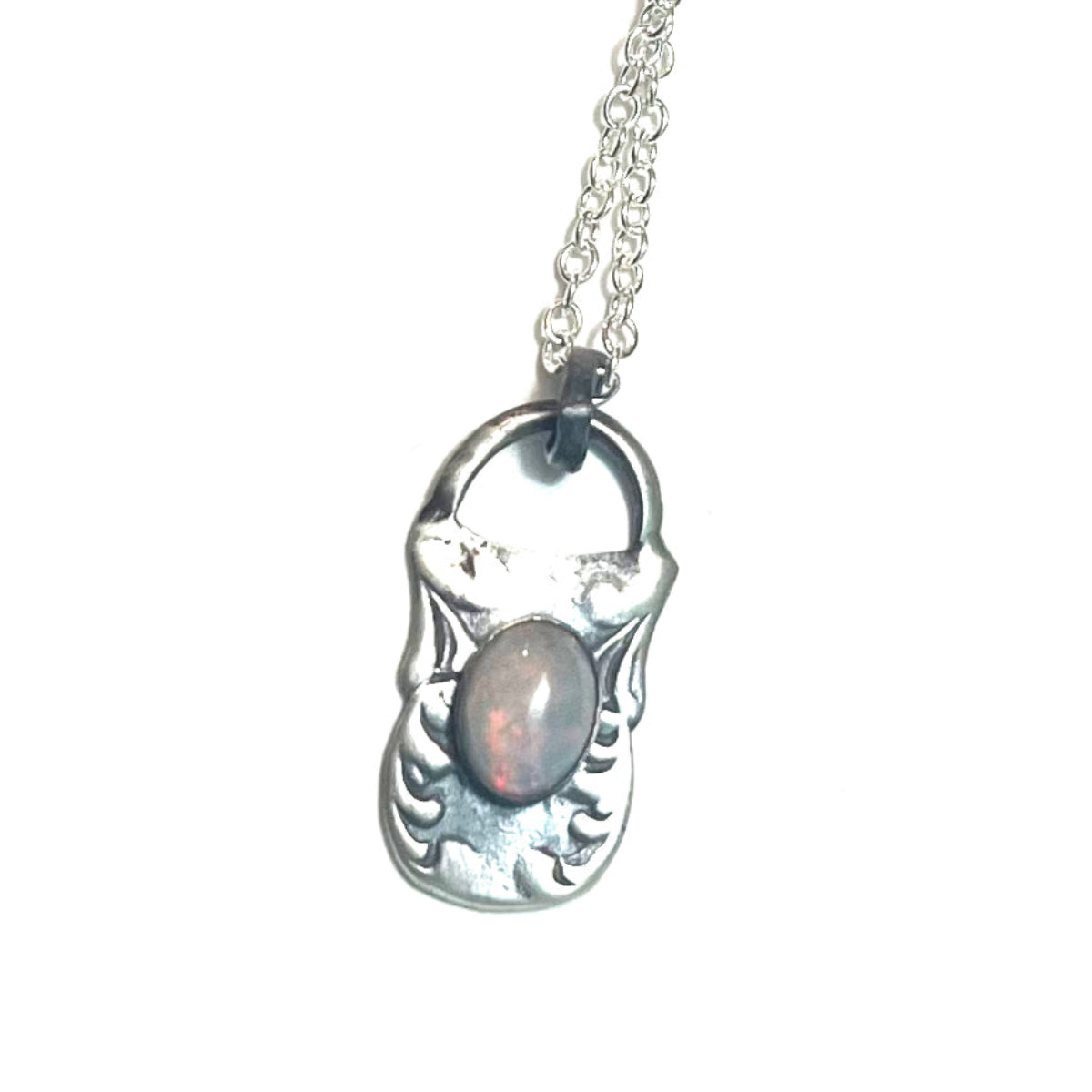 Silver pendant necklace with an opal stone on a white background