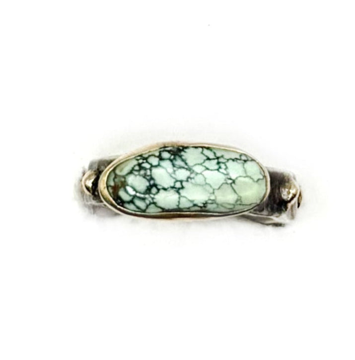 Ring with a green gemstone on a white background