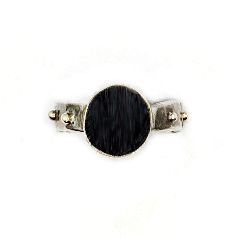 Small black circular object with metallic accents on a white background