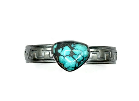 Turquoise stone ring with silver band on a white background