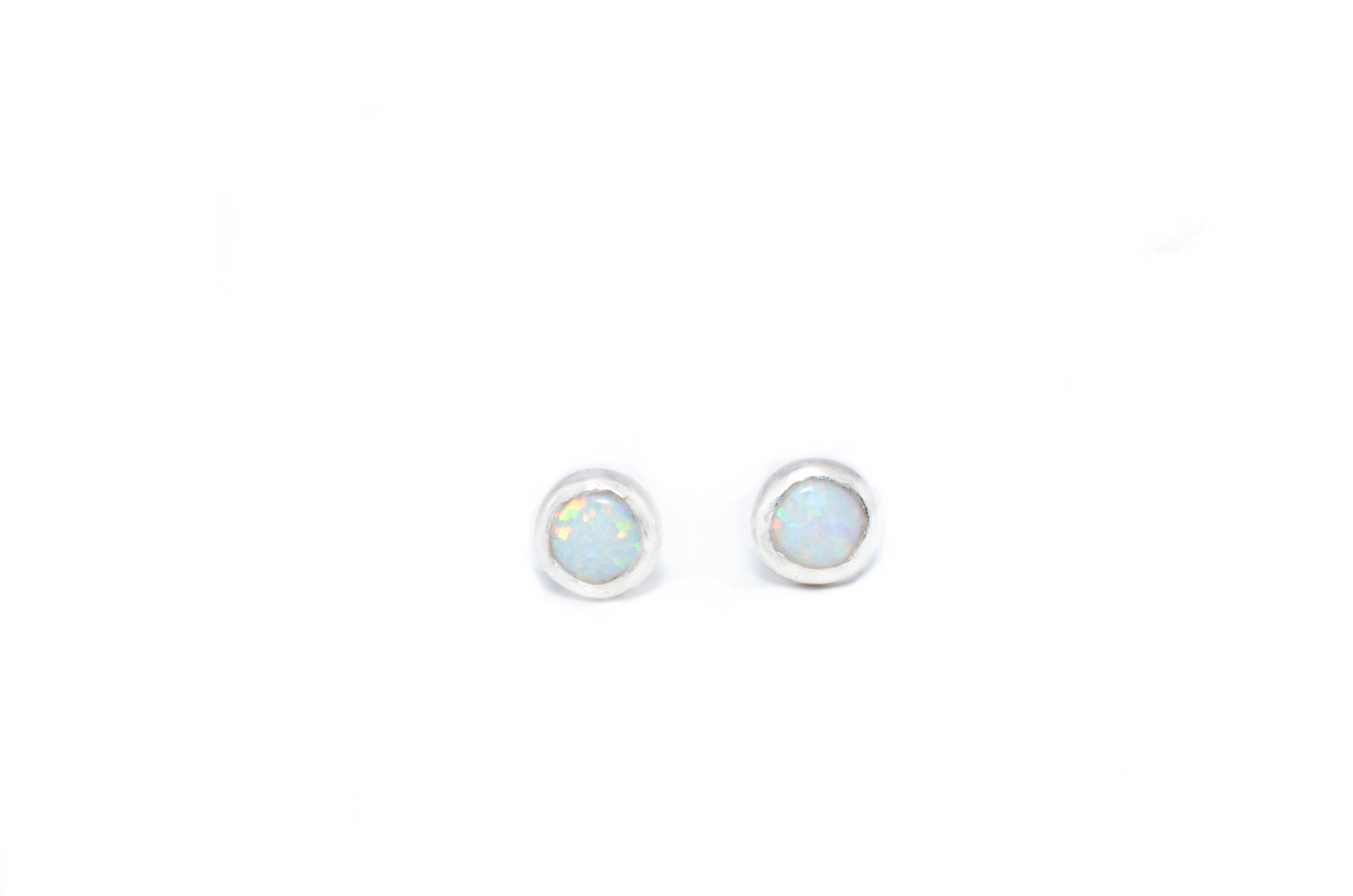 Pair of round earrings with a light blue gemstone on a white background